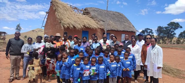 Les élèves d’Ambohimanarina-Ankazobe en blouse, leurs fournitures à la main, devant leur école