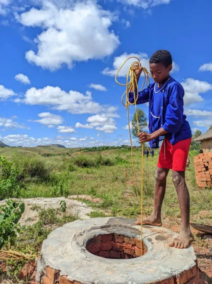 Un enfant tire de l’eau au puits